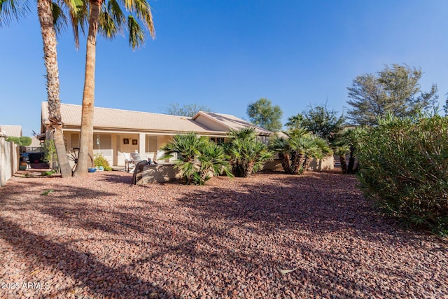 view of front of property featuring a patio area and fence