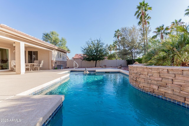 view of swimming pool featuring a fenced in pool, a fenced backyard, and a patio