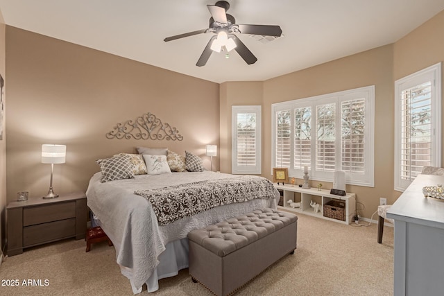 carpeted bedroom featuring ceiling fan and multiple windows