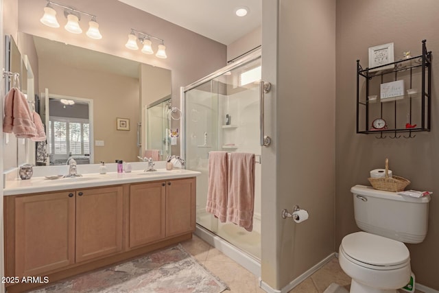 bathroom with toilet, vanity, a shower with door, and tile patterned floors