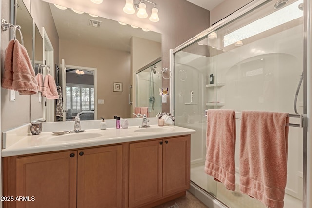 bathroom with vanity, ceiling fan, and a shower with door