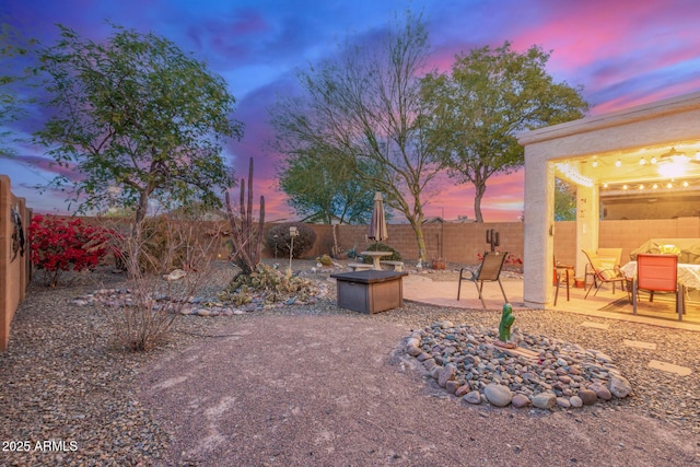 yard at dusk featuring a patio