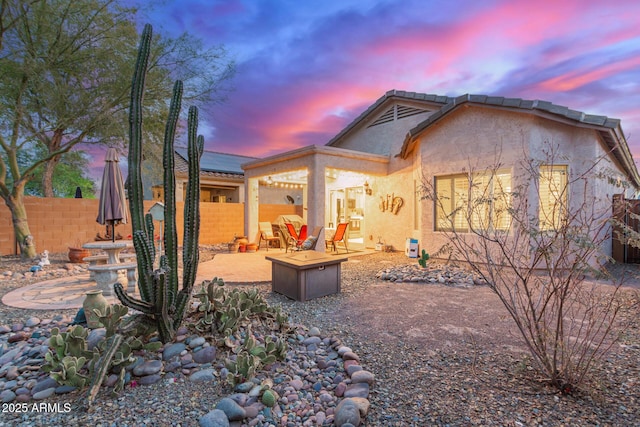 property exterior at dusk featuring a patio