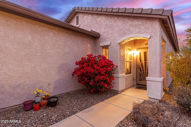 view of exterior entry at dusk