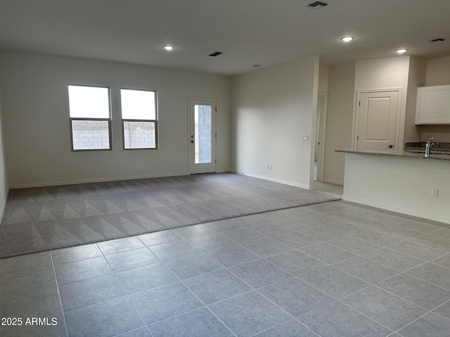 unfurnished living room featuring sink