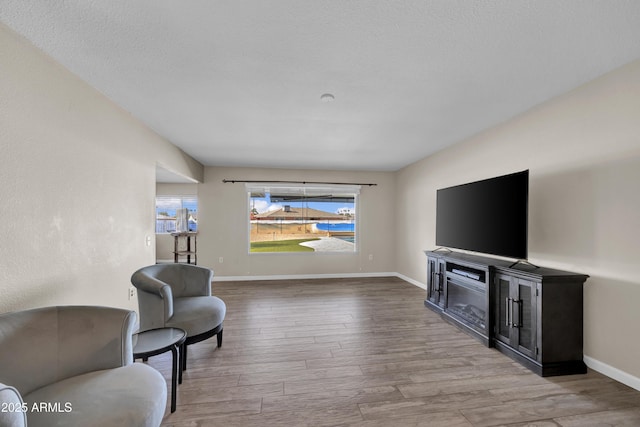 sitting room with a textured ceiling, a wealth of natural light, and wood-type flooring