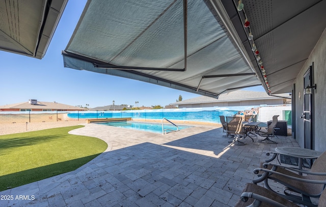 view of swimming pool featuring a patio and a lawn