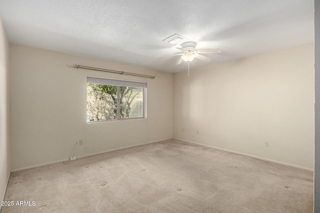 spare room featuring carpet, baseboards, and a textured ceiling