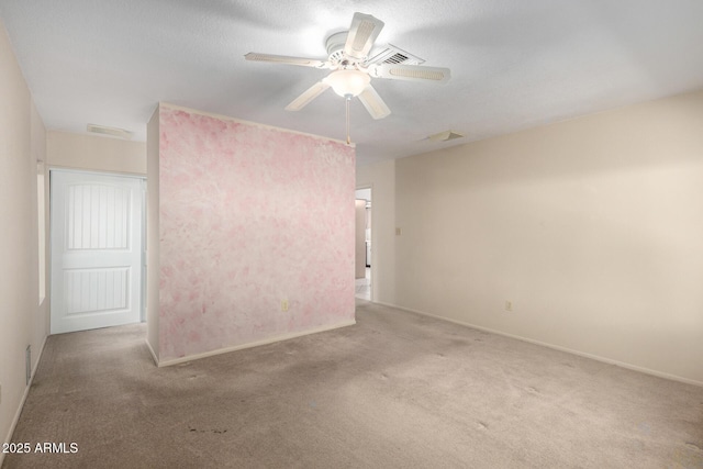 spare room featuring carpet floors, visible vents, ceiling fan, a textured ceiling, and baseboards