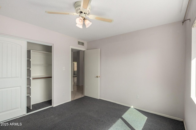 unfurnished bedroom featuring carpet floors, ceiling fan, visible vents, and a closet