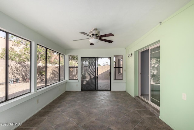 unfurnished sunroom featuring a ceiling fan