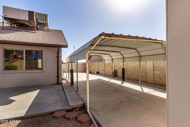 view of patio / terrace with a detached carport and fence