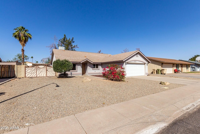 ranch-style house with concrete driveway, fence, an attached garage, and a gate