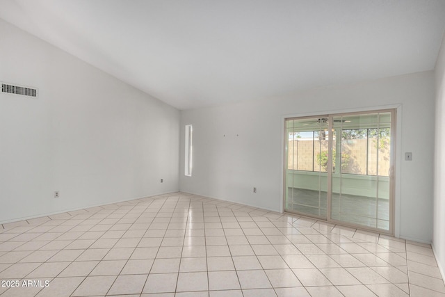 spare room with lofted ceiling, visible vents, and light tile patterned flooring