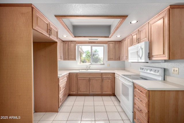 kitchen featuring white appliances, light tile patterned floors, a tray ceiling, light countertops, and a sink