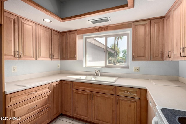 kitchen featuring visible vents, brown cabinets, and a sink