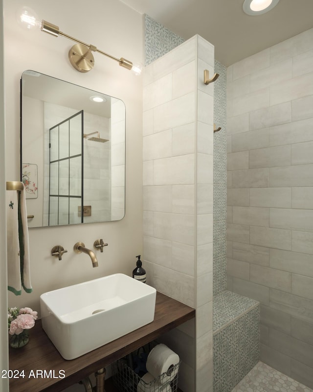 bathroom featuring a tile shower and sink