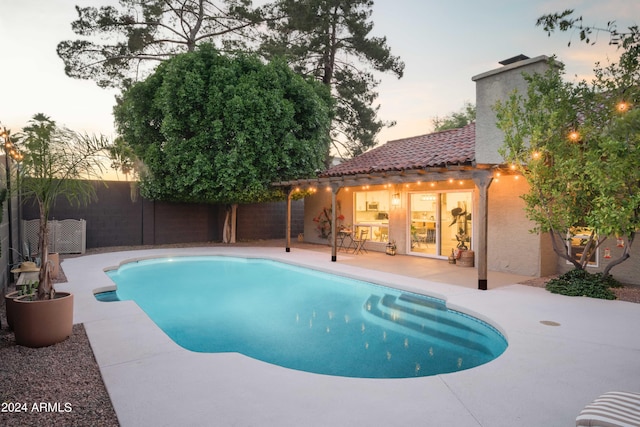 pool at dusk with a patio