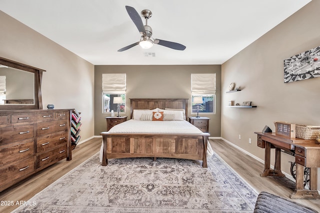 bedroom featuring light wood-style floors, visible vents, and baseboards