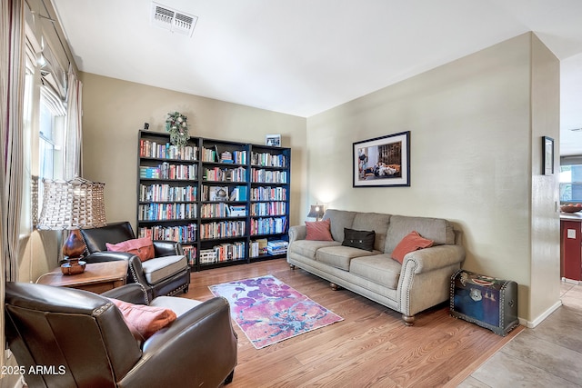 living area featuring visible vents and wood finished floors