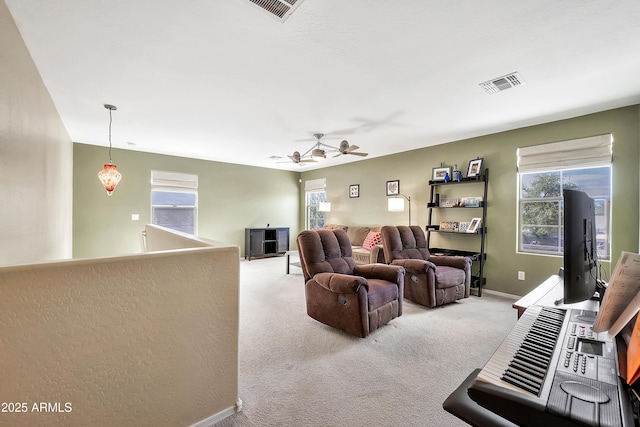 living room featuring plenty of natural light, light colored carpet, and visible vents