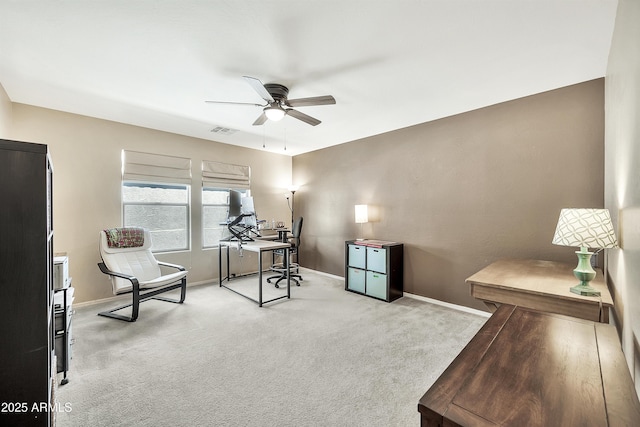 office space with visible vents, carpet flooring, baseboards, and a ceiling fan