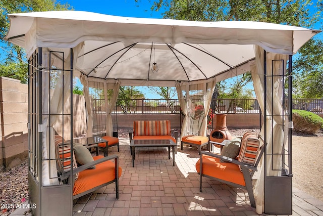 view of patio featuring a gazebo, an outdoor living space, and a fenced backyard