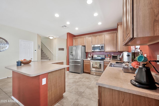 kitchen featuring visible vents, light tile patterned flooring, light countertops, appliances with stainless steel finishes, and a center island