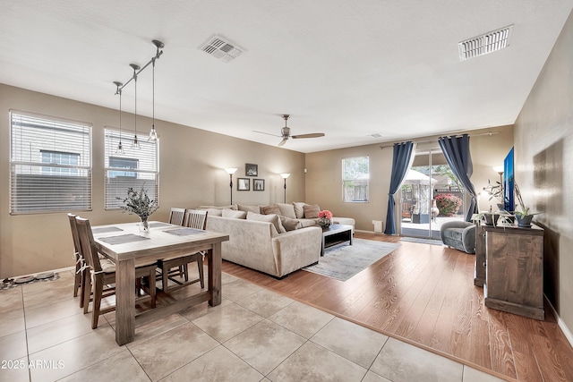 living room with light tile patterned floors, visible vents, and baseboards