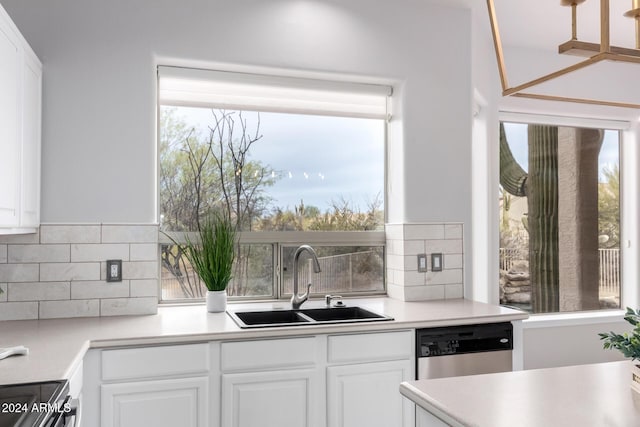 kitchen featuring white cabinets, plenty of natural light, stainless steel dishwasher, and sink