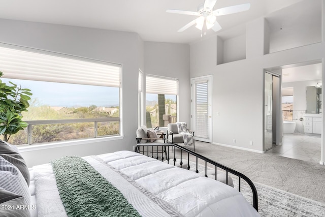 bedroom with ensuite bathroom, ceiling fan, and light colored carpet