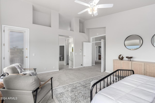 bedroom with ceiling fan, light colored carpet, and a towering ceiling