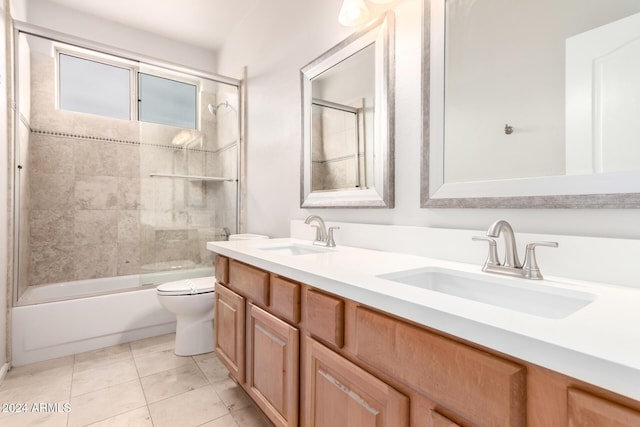 full bathroom with tile patterned floors, vanity, toilet, and bath / shower combo with glass door