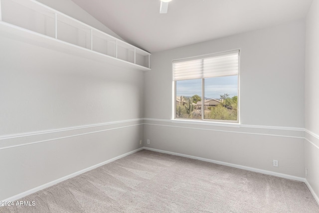 spare room with carpet floors and vaulted ceiling