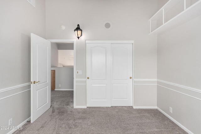 unfurnished bedroom with light carpet and a closet