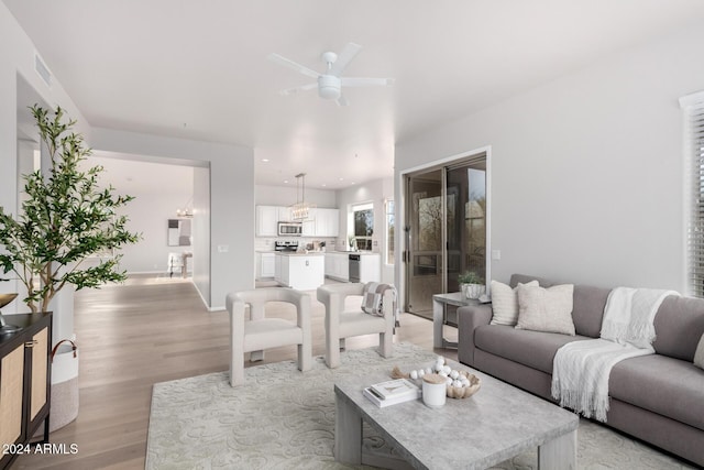 living room featuring ceiling fan and light hardwood / wood-style flooring