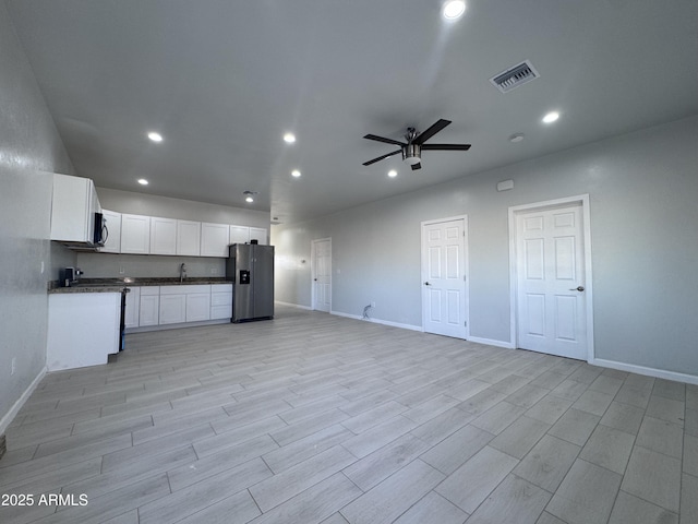 interior space with white cabinetry, appliances with stainless steel finishes, sink, and ceiling fan