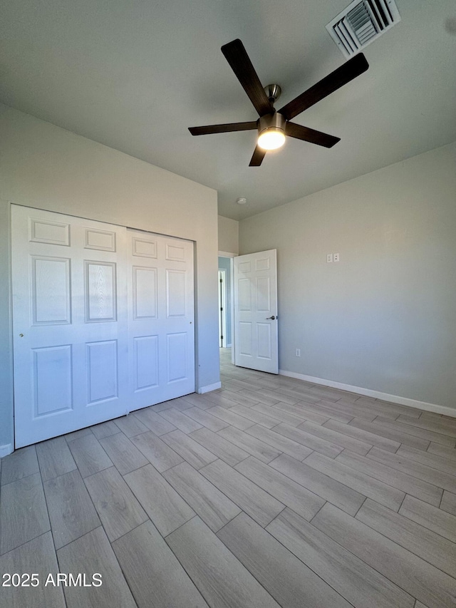 unfurnished bedroom featuring ceiling fan, light hardwood / wood-style floors, and a closet