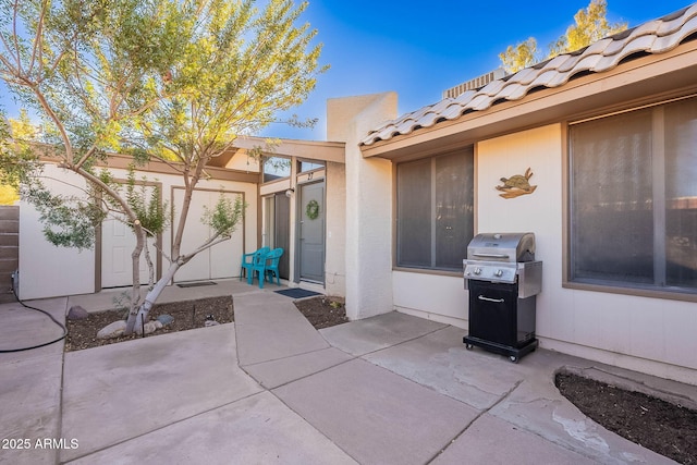 view of exterior entry with a patio area