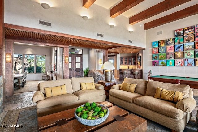 living room featuring beam ceiling, bar, and pool table