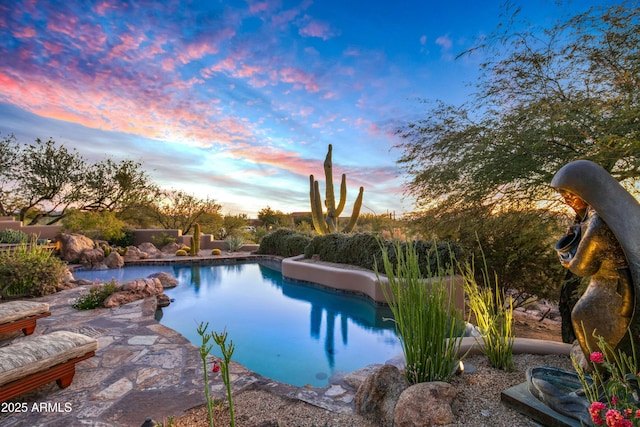 pool at dusk with a patio