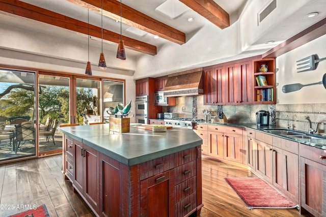 kitchen with decorative backsplash, custom exhaust hood, double oven, sink, and hardwood / wood-style floors