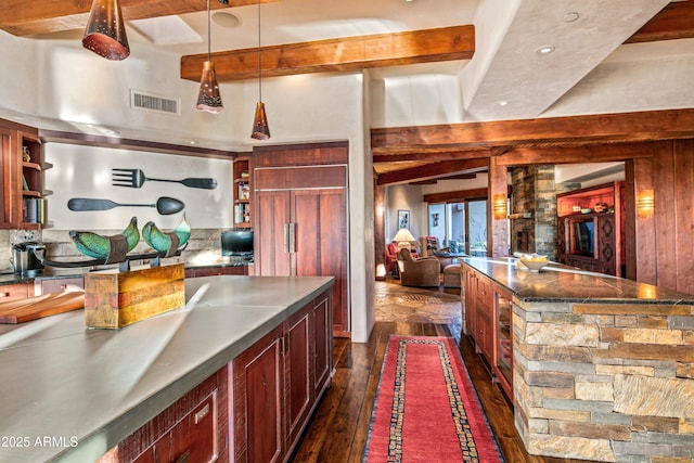 kitchen with decorative light fixtures, beam ceiling, and dark hardwood / wood-style flooring