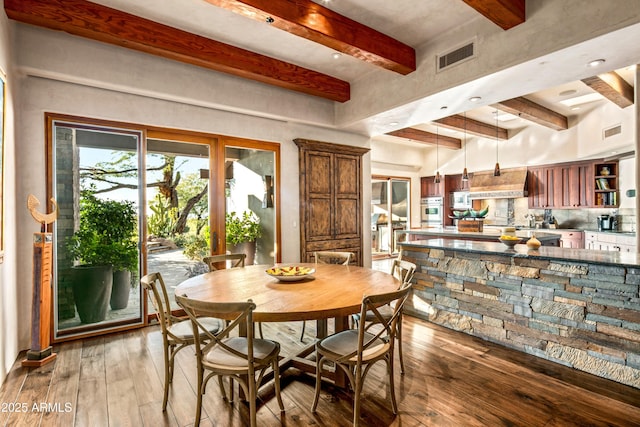 dining area with hardwood / wood-style floors and beamed ceiling