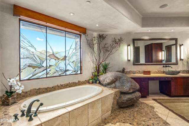 bathroom with vanity and a relaxing tiled tub