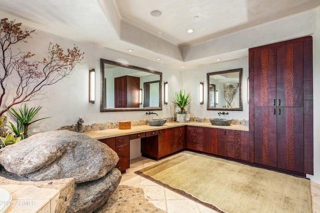 bathroom featuring a raised ceiling and vanity