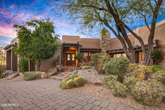 pueblo-style home featuring french doors