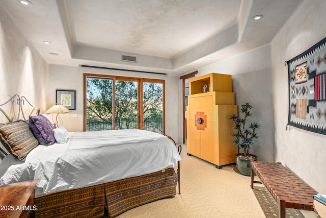 bedroom featuring access to outside, light carpet, and a tray ceiling