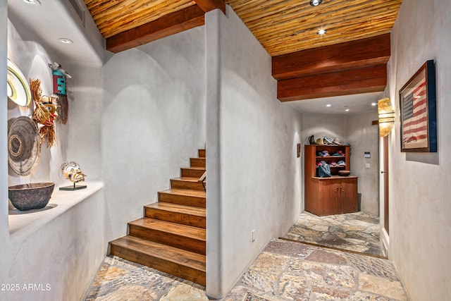 stairs featuring beam ceiling and wood ceiling