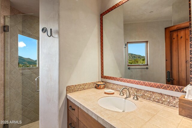 bathroom with a wealth of natural light, a mountain view, vanity, and a shower with shower door